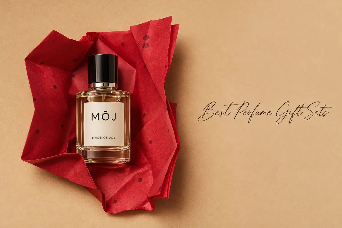 MOJ Made of Joy perfume bottle with black cap lying on crumpled red polka-dot tissue paper against a kraft paper background, with the words Best Perfume Gift Sets in script
