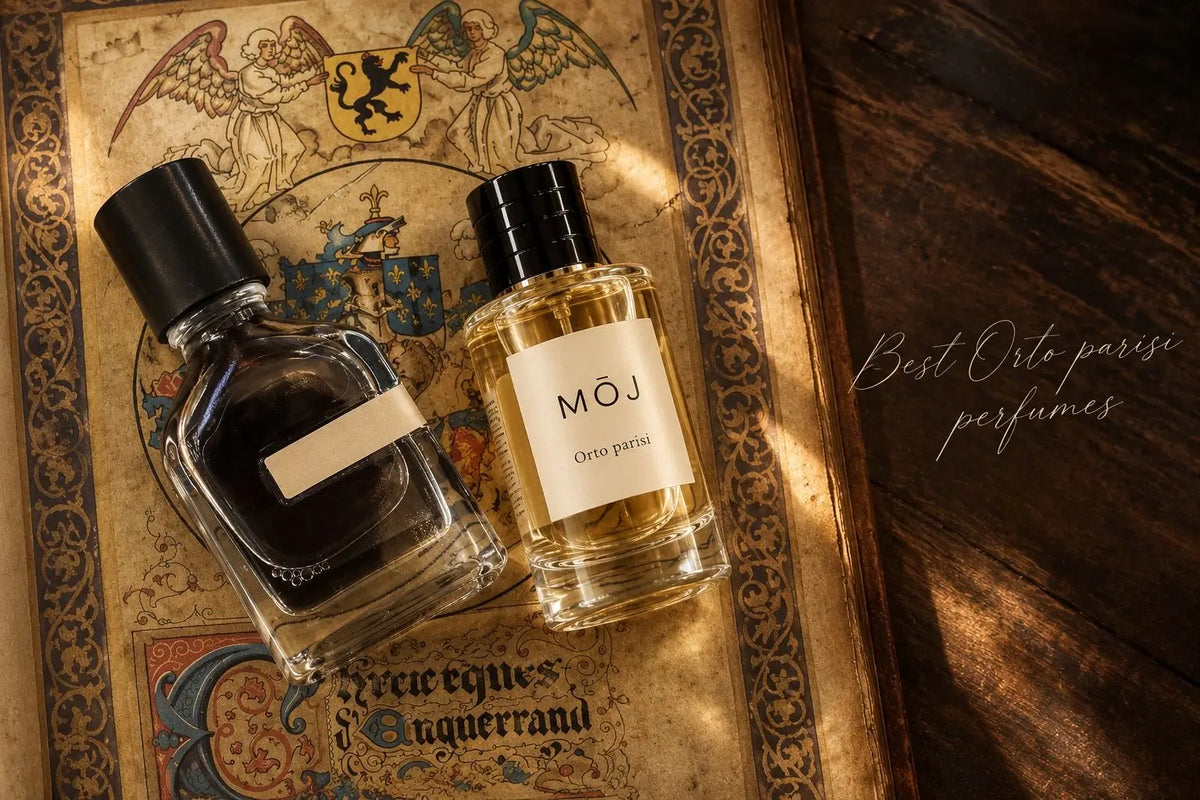 MOJ Orto Parisi perfume bottle with black cap beside a dark Orto Parisi bottle with a blank label, both lying on an illuminated medieval manuscript page with angels and a coat of arms